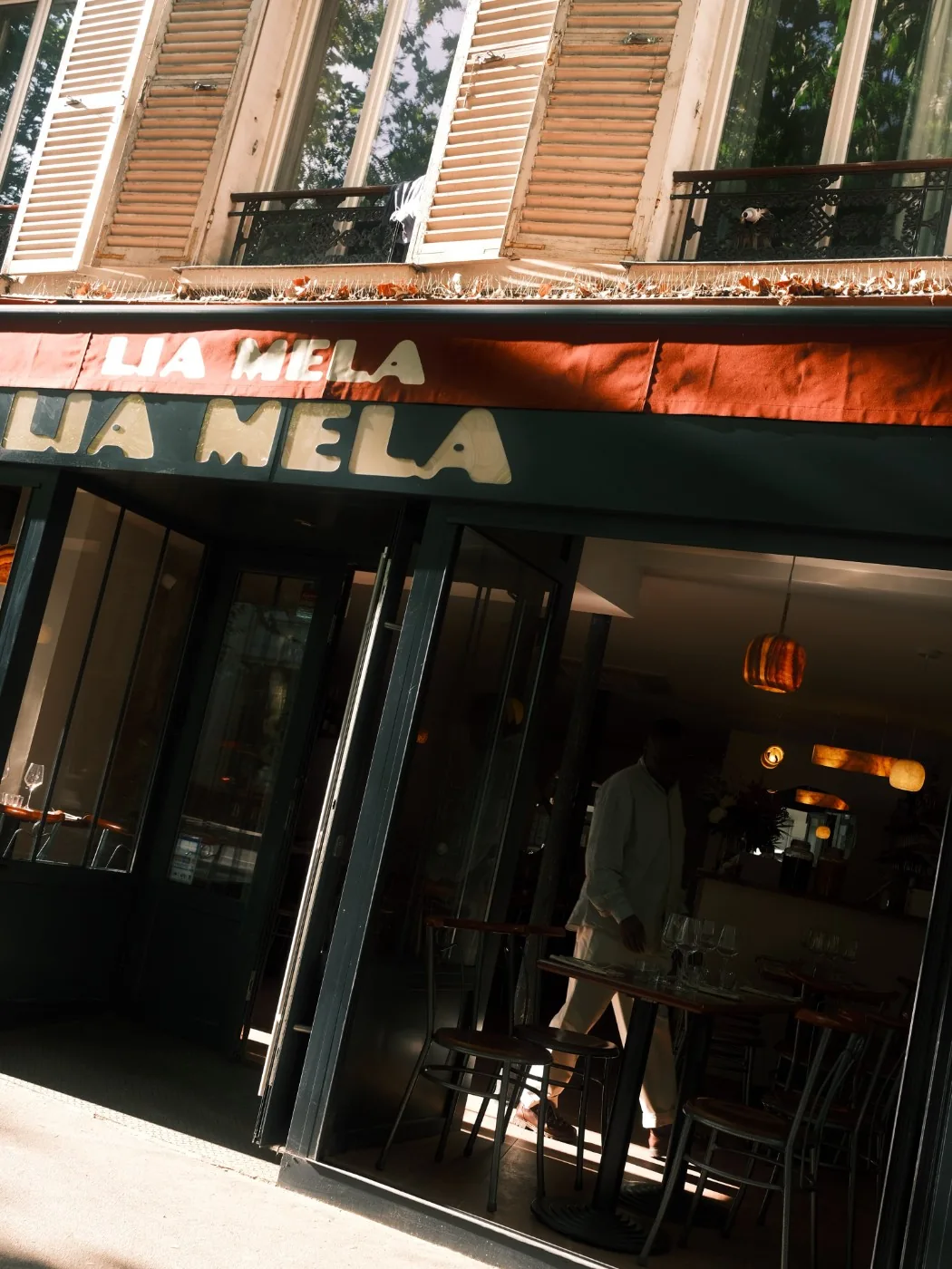 La devanture de Lia Mela le soir, store terracotta et lumière chaude